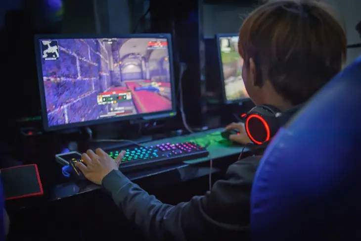 A kid playing video games on his new computer